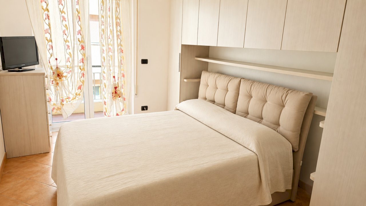 Camera da letto luminosa con tende floreali - Appartamento Rapallo - foto 2